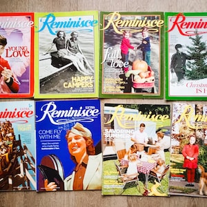 May include: A collection of ten vintage magazine covers featuring the word "Reminisce" in a bold, red font. The covers depict various themes, including young love, happy campers, fall in love, Christmastime, come fly with me, savoring summer, and sweet autumn. Each cover features a unique illustration or photograph.