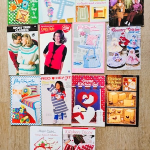 May include: A collection of fourteen vintage craft instruction booklets featuring knitting and crochet patterns for garments, dolls, kitchen decor, and accessories, with colorful photographic covers displaying finished projects and descriptive text.