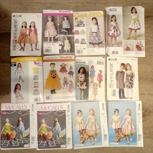 May include: A collection of children's sewing patterns featuring various dress designs. The patterns include brands like Simplicity, McCall's, Butterick, and New Look. The covers showcase illustrations of girls in dresses, skirts, and tops.