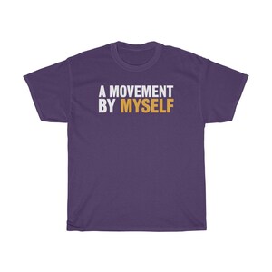 以下が含まれることがあります： 白とオレンジの文字で「A MOVEMENT BY MYSELF」と書かれた紫色のTシャツ