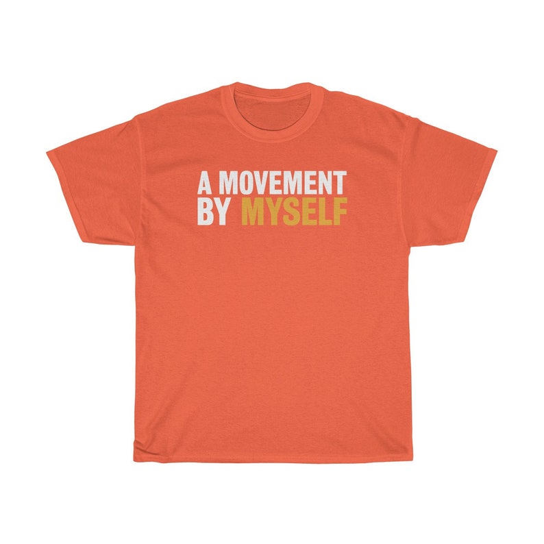 以下が含まれることがあります： コーラルオレンジのTシャツに、白い文字と金色の文字で「A MOVEMENT BY MYSELF」と書かれています。