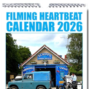 May include: A calendar featuring a blue Land Rover parked in front of a building with a sign that reads "Scripps Funeral Services". The building also has a sign that reads "Aidensfield Garage". The calendar is titled "Filming Heartbeat Calendar 2026".