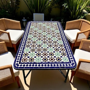 May include: An outdoor dining set with a mosaic-tiled table and four wicker chairs. The table has a rectangular top with a pattern of blue, brown, and green tiles. The chairs have white cushions, creating a stylish garden furniture set.