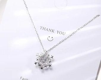 May include: A silver necklace with a snowflake pendant featuring clear cubic zirconia stones. The necklace is displayed on a white card with the text "Thank You" and a smiley face. The card also says "Fashion Accessories".