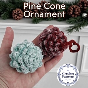 May include: Two handmade pine cone ornaments, one teal and one burgundy, are held in a hand. The burgundy ornament has a red loop for hanging. The text "Pine Cone Ornament" is at the top of the image.