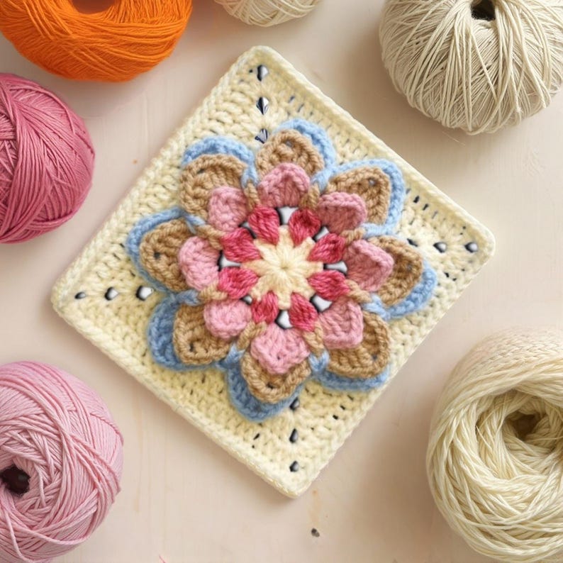 May include: A colorful crochet flower square in shades of pink, blue, tan, and cream. The square is surrounded by balls of yarn in various colors, including pink, orange, and cream. This handmade item is perfect for crafting projects.