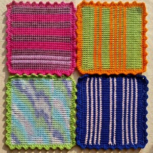 May include: Four colorful, square crochet coasters with scalloped edges. The coasters feature striped patterns in pink, green, blue, and purple. Two wooden knitting needles are also present.