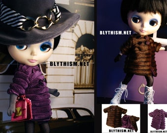 May include: Two Blythe dolls are shown, one in a purple coat and hat, the other in a brown coat. The dolls have large eyes and are wearing fashionable clothing. The website address BLYTHISM.NET is visible in the image.