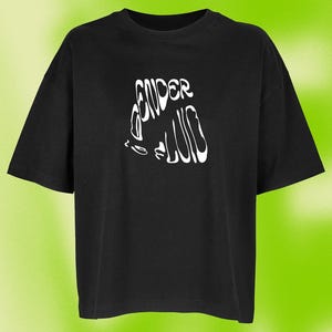 Könnte beinhalten: Ein schwarzes T-Shirt mit kurzen Ärmeln und einem weißen Grafikdruck auf der Brust. Das Design besteht aus den Worten "GENDER FLUID" in einer verzerrten, wellenförmigen und stilisierten Schriftart. Das Kleidungsstück hat einen Rundhalsausschnitt.