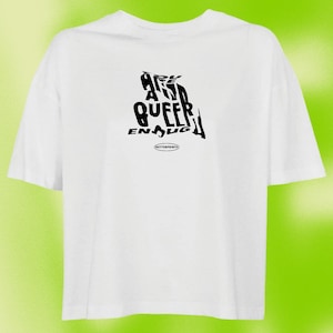 Könnte beinhalten: Weißes T-Shirt mit einem schwarzen Grafikdruck, der "Bist du queer genug?" in einer verzerrten Schriftart lautet. Die Grafik ist mittig auf dem Shirt platziert und von einem weißen Rand umgeben. Das Shirt hat einen Rundhalsausschnitt und kurze Ärmel.