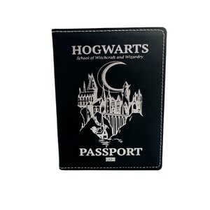 May include: Black leather passport holder with a white embossed Hogwarts logo, including the school's name, crest, and the words "School of Witchcraft and Wizardry" and "Passport".