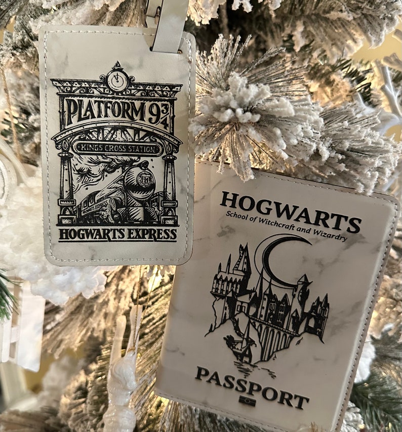 May include: Two white luggage tags with black text and images. The first tag features a black and white illustration of a train with the text "Platform 9 3/4 Kings Cross Station Hogwarts Express". The second tag features a black and white illustration of Hogwarts castle with the text "Hogwarts School of Witchcraft and Wizardry Passport".