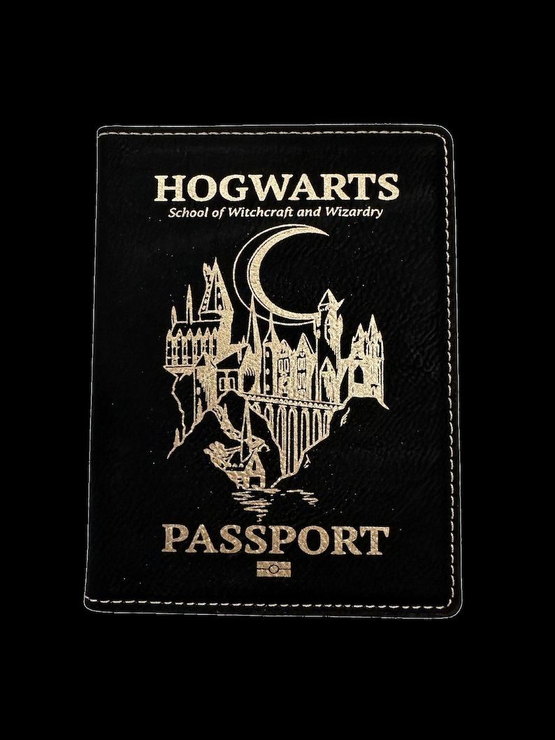 May include: Black leather passport holder with gold lettering that reads "HOGWARTS School of Witchcraft and Wizardry" and "PASSPORT". The holder features a gold silhouette of Hogwarts castle with a crescent moon.