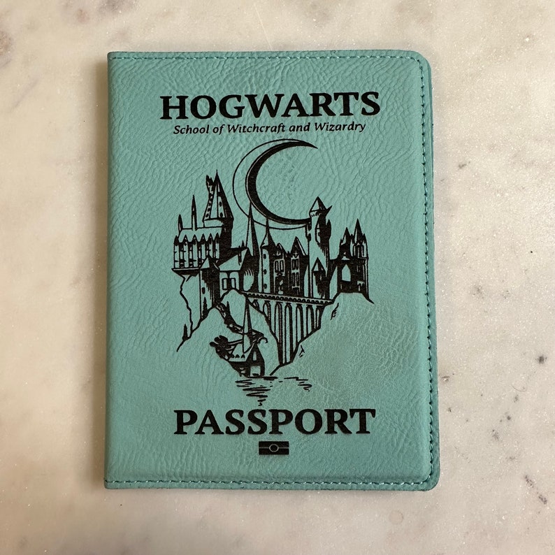 May include: A teal blue passport holder with the words "HOGWARTS School of Witchcraft and Wizardry" and a black silhouette of Hogwarts castle with a crescent moon above it. The words "PASSPORT" are printed below the castle.