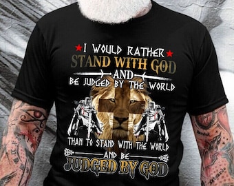 May include: Black t-shirt with a lion and two knights in front of a cross. The text reads "I would rather stand with God and be judged by the world than to stand with the world and be judged by God."