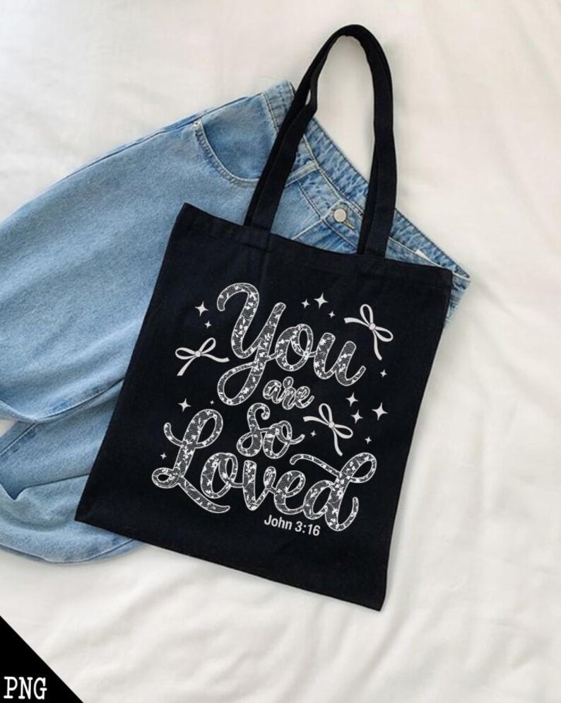 May include: Black tote bag with a white design that says "You are so Loved" with a small bow and stars. The text "John 3:16" is at the bottom of the design.