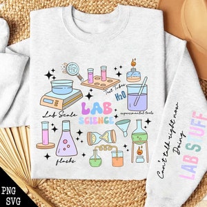 May include: A light gray sweatshirt with a colorful science themed design. The design includes a lab scale, test tubes, flasks, beakers, a funnel, and a Bunsen burner. The text "Lab Science" is written in rainbow colors. The text "Can't talk right now doing lab stuff" is written on the sleeve.
