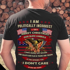 Può includere: Maglietta nera con un design grafico che presenta una bandiera americana, un'aquila e il testo "Sono politicamente scorretto, dico Buon Natale, Dio benedica l'America. Possiedo armi, mangio pancetta e saluto la nostra bandiera e ringrazio le nostre truppe. Se questo ti offende, non me ne frega niente. In Dio confidiamo."
