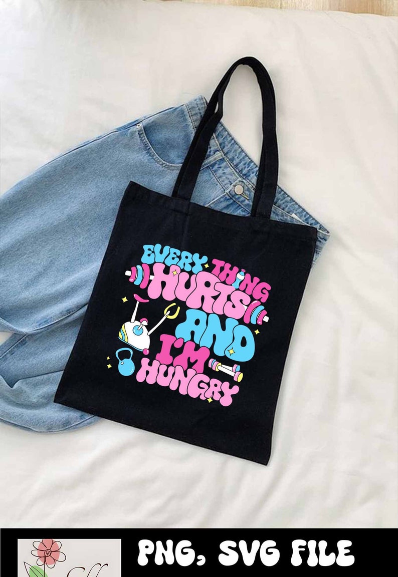 Pu&ograve; includere: Borsa tote nera con una grafica rosa e blu che dice "Tutto fa male e ho fame". La grafica include un manubrio, un kettlebell e un bilanciere.