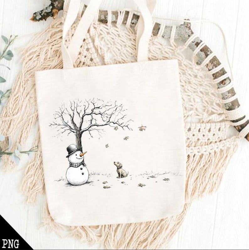May include: A white tote bag with a black and white illustration of a snowman and a dog standing in front of a bare tree. The tote bag has a brown strap.