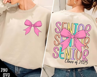 May include: A beige sweatshirt with a pink bow on the front and the words "Senior Class of 2025" with a pink bow on the back.