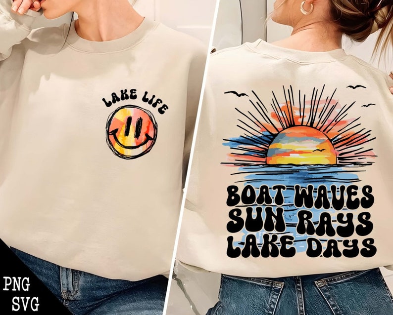 May include: A light beige sweatshirt with a smiley face and the text "Lake Life" on the front. The back of the sweatshirt has a sunset graphic with the text "Boat Waves Sun Rays Lake Days".