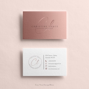 May include: Two business cards with a rose gold background. The top card has the text "CHRISTINE LANCE PROFESSIONAL MAKEUP ARTIST" with a stylized "CL" logo. The bottom card has the same logo in a circle with the text "CHRISTINE LANCE PROFESSIONAL MAKEUP ARTIST" around the circle. The bottom card also has contact information including an address, phone number, email address, and website.
