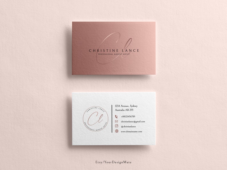 May include: Two business cards with a rose gold background. The top card has the text "CHRISTINE LANCE PROFESSIONAL MAKEUP ARTIST" with a stylized "CL" logo. The bottom card has the same logo in a circle with the text "CHRISTINE LANCE PROFESSIONAL MAKEUP ARTIST" around the circle. The bottom card also has contact information including an address, phone number, email address, and website.