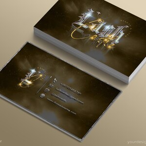 May include: A gold and silver business card with the word "Lush" in a stylized font. The card has a dark brown background with a subtle sparkle effect. The card includes contact information such as a phone number, email address, and website address.