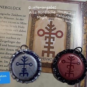 Puede incluir: Dos colgantes con símbolos nórdicos, uno azul y plateado, el otro rojo y negro, con un fondo de texto e ilustraciones. El texto incluye "MÄNNERGLÜCK" y "Jane's Fashion & Art."