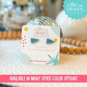 May include: A pair of blue glitter triangle stud earrings on a white card with the text "ellie and ginger party gifts apparel" and "Oh yes, friend These were definitely made for you!"  The card also includes the website address "www.EllieandGinger.com".