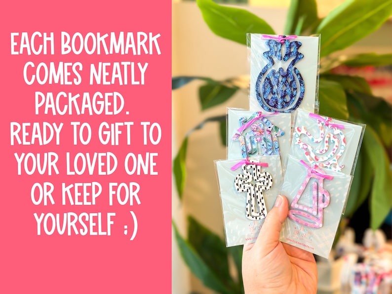 May include: Five different patterned bookmarks are displayed in their individual packaging. Each bookmark is made of wood and features a different design, including a pineapple, a house, a bird, a cross, and a megaphone. The bookmarks are ready to be gifted or kept for oneself.