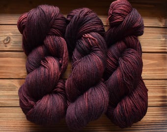 Black Cherry: Hand-dyed, Merino Wool Nylon Superwash Fingering Sock Yarn. Sport Weight. Tonal red yarn. Dark red yarn. Semi-solid yarn.