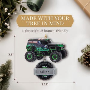 May include: A Grave Digger monster truck ornament, 3.5 inches high and 3.25 inches wide, with the name "Killian" on a tire-shaped tag. The ornament is black and green with the text "MADE WITH YOUR TREE IN MIND".