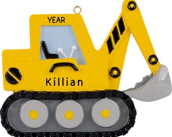 Puede incluir: Adorno de Navidad de excavadora de juguete amarilla con rayas negras y blancas en el brazo, orugas grises y el nombre "Killian" y la palabra "YEAR" en la parte delantera.