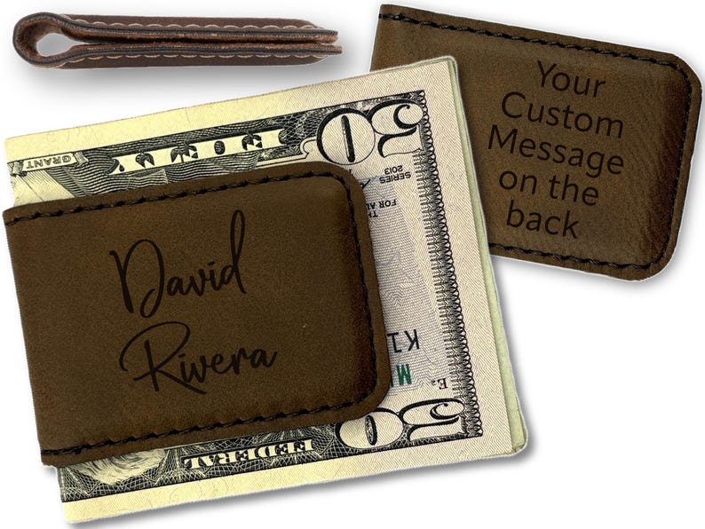 May include: A brown leather money clip with the name 'David Rivera' engraved on the front. The back of the money clip has the text 'Your Custom Message on the back' engraved on it. The money clip is holding a twenty dollar bill.