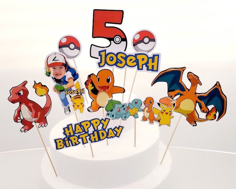 May include: A cake topper set featuring a red, yellow, and blue Pokemon character, a red and yellow Pokemon character, a blue and orange Pokemon character, a yellow Pokemon character, a blue and green Pokemon character, a red and yellow Pokemon character, a red and yellow Pokemon character, a red number 5, a Pokeball, and the text "Happy Birthday Joseph".