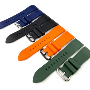 Może przedstawiać: Cztery r&oacute;żne kolorowe paski do zegarka, w tym niebieski, czarny, pomarańczowy i zielony. Paski są wykonane z silikonu i mają zapięcie na klamrę.