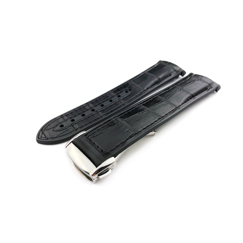 May include: Black leather watch strap with a silver buckle. The strap has a crocodile pattern.