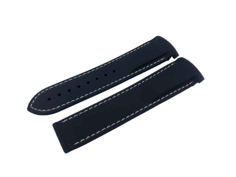 Puede incluir: Dos correas de reloj azul marino con costuras blancas. Las correas est&aacute;n hechas de un material flexible y tienen agujeros de ajuste. El dise&ntilde;o incluye un extremo redondeado y un extremo rectangular.