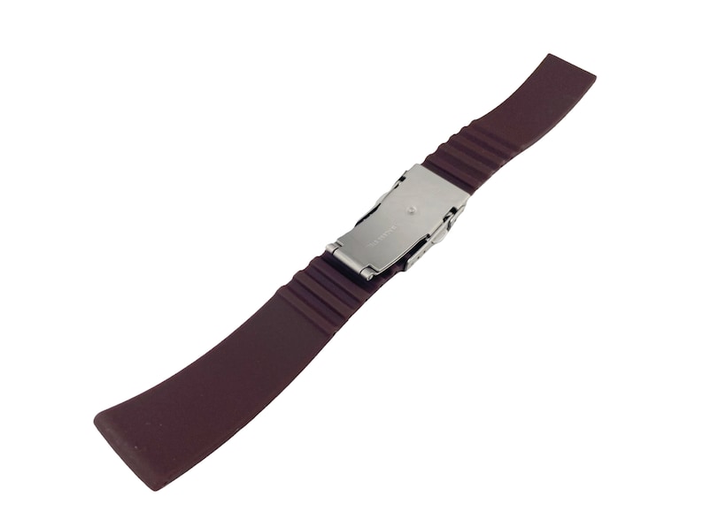 Puede incluir: Una correa de reloj de caucho marr&oacute;n oscuro con una hebilla plateada.