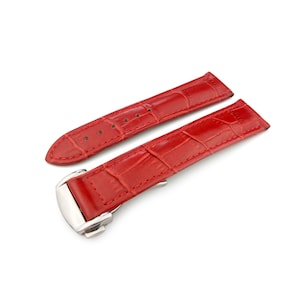 Puede incluir: Una correa de reloj de cuero rojo con estampado de cocodrilo y hebilla plateada.