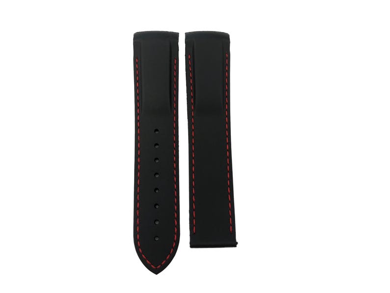 May include: Two black watch straps with red stitching. One strap has multiple holes for adjustment. The straps are made of a smooth material and are designed to attach to a watch face. The straps are shown against a white background.