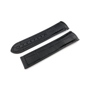 May include: Two black leather watch straps with a crocodile pattern. The straps are laid out flat on a white background.