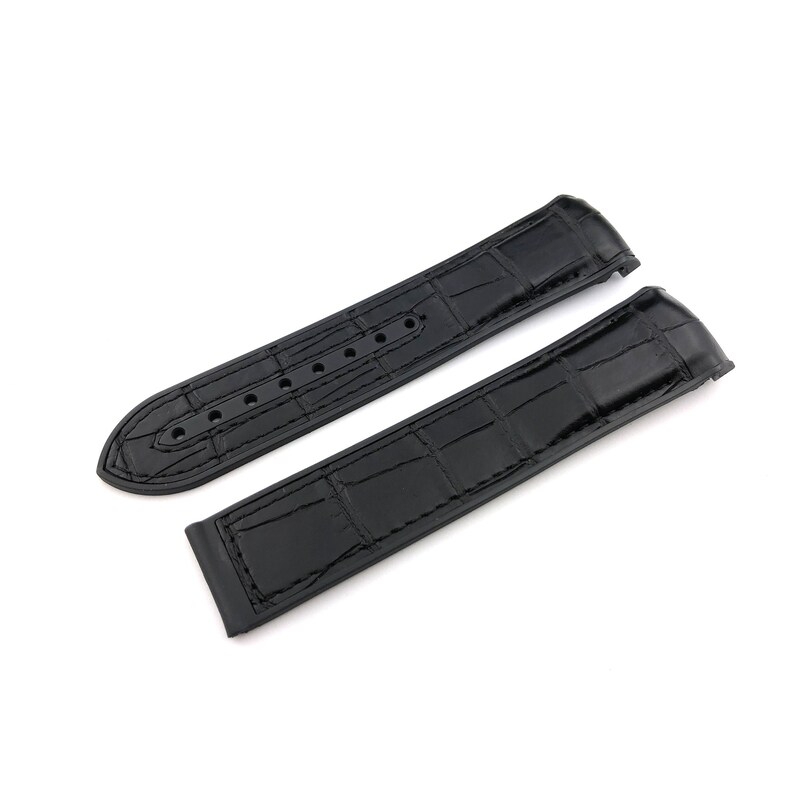 May include: Two black leather watch straps with a crocodile pattern. The straps are laid out flat on a white background.