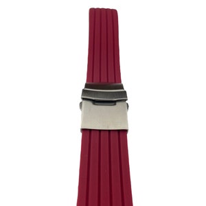 May include: A red silicone watch strap with a silver buckle.