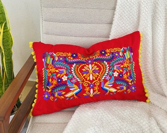 Örngott i ländryggen med rött och blått mexikanskt broderi och pompoms i Otomi-stil, perfekt för mexikansk dekoration.
