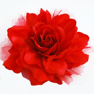 May include: A large, red fabric rose with a ruffled texture. The rose is made of a soft, silky material and has a delicate, layered appearance.