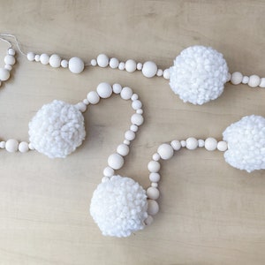 Guirnalda de cuentas de madera natural con pompones