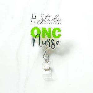 May include: A clear badge reel with the text "ONC Nurse" in green and black script. The badge reel has a retractable cord and a clip for attaching to clothing. The background is white.